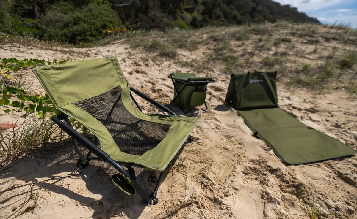 An Often low camping chair next to the cooler-bag chair and a rolled mat on a Queensland dune
