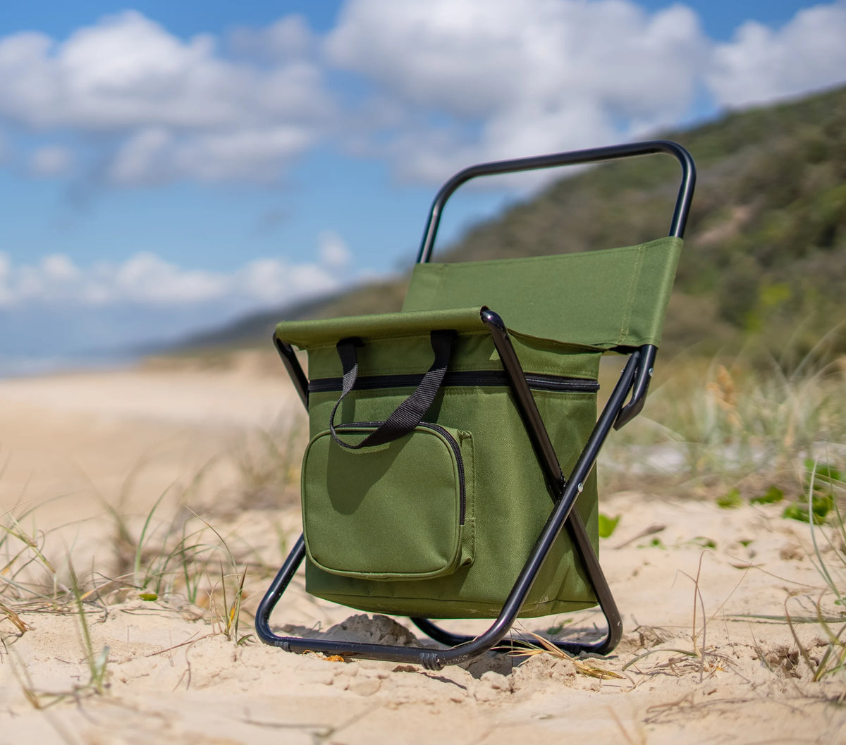 The Often folding stool with its insulated cooler bag under the seat, standing on a Queensland dune with the beach running away behind it